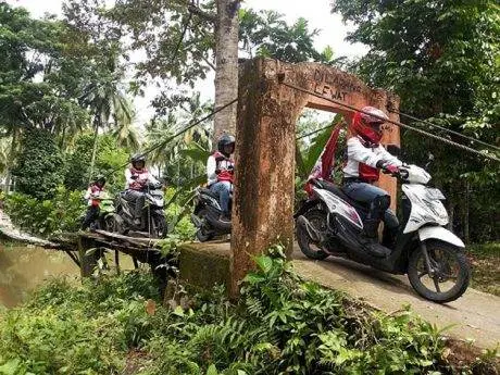 Riders melewati jembatan rusak di daerah Krui